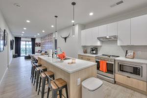 una cocina con armarios blancos y una isla con taburetes. en 3br 2ba Luxury Pool 08mi To Broadway Gulch, en Nashville