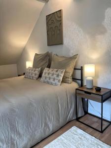 a bedroom with a bed with two pillows and a table at La Mansarde - Cœur Historique, Charme et Confort in Brive-la-Gaillarde