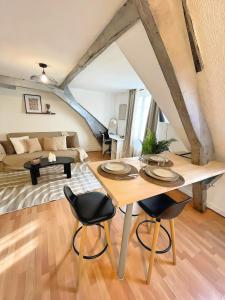 a living room with a table and chairs at La Mansarde - Cœur Historique, Charme et Confort in Brive-la-Gaillarde
