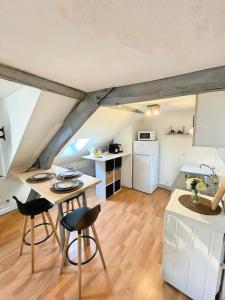 a kitchen and living room with a table and chairs at La Mansarde - Cœur Historique, Charme et Confort in Brive-la-Gaillarde