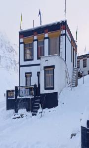 a house in the snow with snow covered ground at Sunflower Homestay By StayApart in Kibar