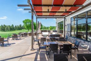 un patio al aire libre con mesas, sillas y ventanas en Little Crow Resort & Conference, Trademark by Wyndham, en Spicer