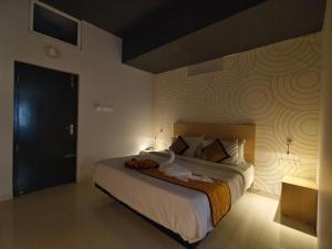 Un dormitorio con una cama grande con una pared. en Skyry Residency Tidel Park, en Coimbatore