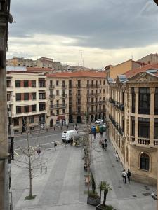 una calle de la ciudad con edificios y gente caminando por ahí en Roomin Hostel, en Salamanca