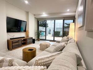 a living room with a large couch and a tv at Cottesloe Beachouse in Perth