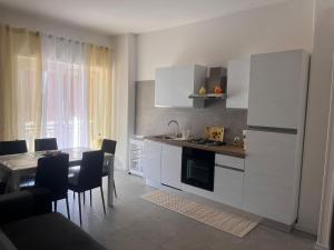 a kitchen with white cabinets and a table with chairs at la perla in Nettuno