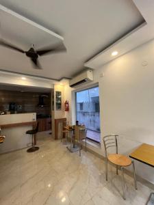 a kitchen and dining room with a ceiling fan at Ostro Inn New Town in kolkata