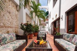 patio con divani e un cesto di frutta su un tavolo di Luxury Apartment Private Pool & Rooftop Jacuzzi a Cartagena de Indias