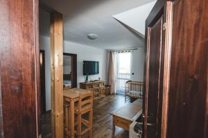 a living room with a table and a television at wellness Chata u Pinkasů in Písečná