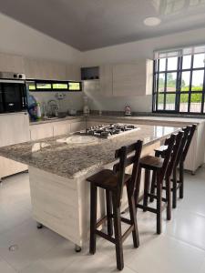 una cucina con una grande isola con sgabelli da bar di Chalet Casa Campestre Villa del Sol a La Tebaida