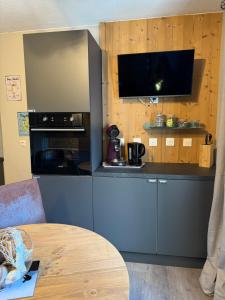 eine Küche mit einer Theke mit einem Herd und einem Tisch in der Unterkunft Logement cosy à la montagne in Bourg-Saint-Maurice