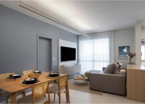 a living room with a table and a couch at Resort piscina aquecida suíte e churrasqueira in Florianópolis