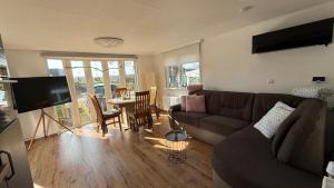 a living room with a couch and a table at Chalet am Rhederlaag in Lathum