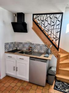 a kitchen with a sink and a staircase at Maison de campagne, Gîte rouge in Brigné +17 photos