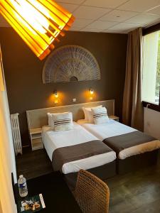 Postel nebo postele na pokoji v ubytování Cit'Hotel Le Louvre Orange