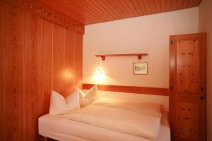 ein Schlafzimmer mit einem Bett mit weißen Kissen in der Unterkunft Gästehaus Etschmann in Riezlern