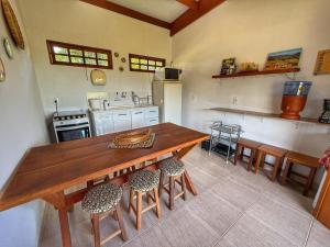 a kitchen with a wooden table and stools at Sons da Canastra Pousada e Terapias - em São José do Barreiro - São Roque de Minas MG in São Roque de Minas