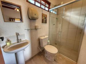 a bathroom with a toilet and a sink and a shower at Sons da Canastra Pousada e Terapias - em São José do Barreiro - São Roque de Minas MG in São Roque de Minas