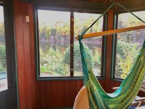 een hangmat in een kamer met een groot raam bij Chalet du lac long in Saint Come