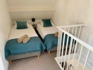 two twin beds in a room with a staircase at Zilt Noordwijk in Noordwijk aan Zee