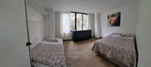 a bedroom with two beds and a window at Cabañas o habitación en Fundo Huabayor in Lima +71 photos