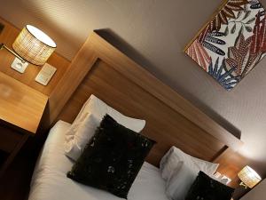 Postel nebo postele na pokoji v ubytování Cit'Hotel Le Louvre Orange