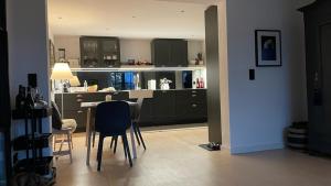 a kitchen with black cabinets and a table and chairs at Alz-Apartment in Seeon-Seebruck