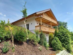 a house with a balcony on top of a hill at Alz-Apartment in Seeon-Seebruck