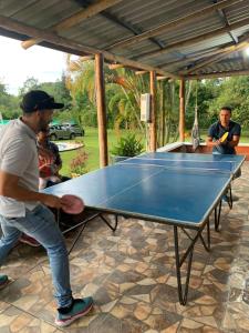 un uomo che gioca a ping pong su un tavolo da ping pong di Chalet Casa Campestre Villa del Sol a La Tebaida