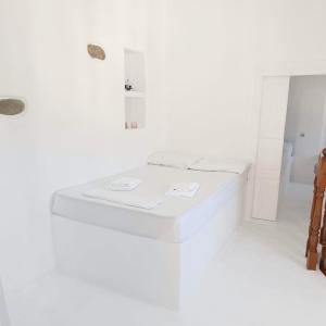 a white room with a bed and a sink at Perno in Serifos Chora