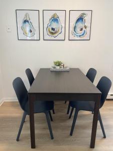 a dining room table with chairs and paintings on the wall at Cozy Oaks Chesapeake Properties in Cape Charles