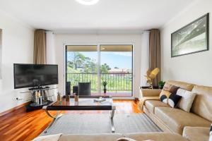 a living room with a couch and a tv at SUPER Atalaia in Caniço