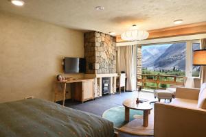 a room with a bed and a living room with a fireplace at Stone Hedge Hotel in Nubra