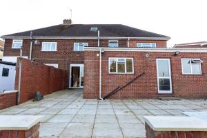 a brick house with a patio in front of it at Newly Refurbed Home With Football Table Near M5 Junction 2 in Oldbury