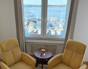 two chairs and a table in front of a window at Studio Apartment Harbour Pula in Pula