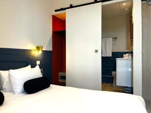 Postel nebo postele na pokoji v ubytování Cit'Hotel Le Louvre Orange