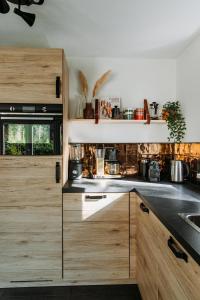 een keuken met houten kasten en een wastafel bij Luxe Vakantiehuis Vosje op de Veluwe Nunspeet in Nunspeet +73 foto's