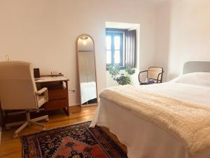 Casas VelhasにあるLike-Home-T2-Kina House-Patioのベッドと机と鏡のある寝室