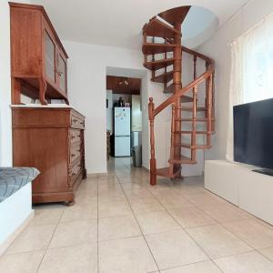 a living room with a staircase and a television at Perno in Serifos Chora