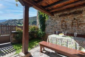 a patio with a table and a wooden bench at Fidalsa Paradise Point in Cabezón de Liébana