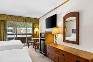 a hotel room with a bed and a mirror at Best Western Adirondack Inn in Lake Placid +70 photos