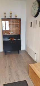 a room with a dresser with a clock on the wall at Virágos Birtok és Vendégház in Villány