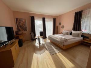 a bedroom with a bed and a flat screen tv at Heppenheimer Hof Hotel in Worms