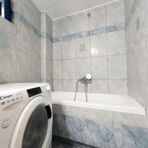 a bathroom with a washing machine and a bath tub at Perno in Serifos Chora