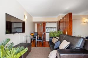 Una sala de estar con un sofá de cuero y una mesa. en SUPER Mar, en Funchal