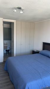 コンセプシオンにあるMaravilloso Departamento En Centro De Concepciónの青い毛布が掛けられた大きなベッドのある寝室