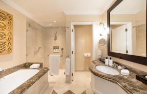 a bathroom with a tub and a sink and a shower at InterContinental Johannesburg OR Tambo Airport Hotel by IHG in Kempton Park