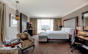 a bedroom with a bed and a desk and a chair at InterContinental Johannesburg OR Tambo Airport Hotel by IHG in Kempton Park