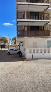 a white car parked in front of a building at Apartamento Neptuno A4 in Puebla de Farnals