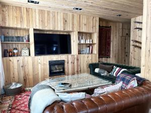 a living room with a leather couch and a table at Nevada suites Dúplex con vistas y acceso a pista in Sierra Nevada